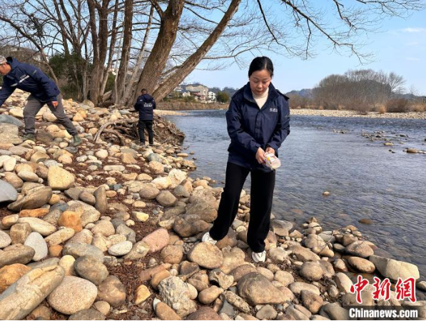 玉龙环保：王丽(前1)组织网格员巡查河道，发现垃圾同步清理